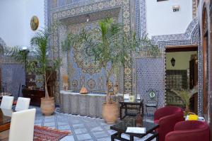 una habitación con una pared de azulejos con macetas. en Riad Le Patio De Fes, en Fez