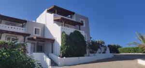 a white house with a white fence at Castri Village Hotel in Palekastron