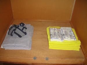 eine Schachtel mit zwei Handtüchern auf einem Holzboden in der Unterkunft Matsuichi in Hamamatsu