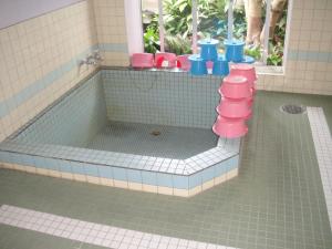 uma banheira de brinquedo numa casa de banho com WC rosa e azul em Matsuichi em Hamamatsu