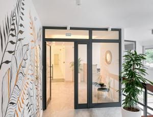 un pasillo con puertas de cristal y una planta en Skaline Luxury rooms Split, en Split