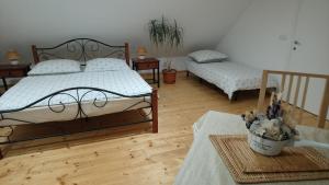 Un dormitorio con 2 camas y una mesa con una planta en Forest Romantic Apartment Brdy, en Věšín