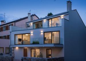 ein großes weißes Haus mit Beleuchtung in der Unterkunft Apartmani Mare verde in Novigrad Istria