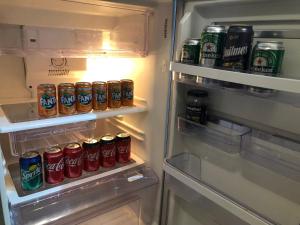 einem offenen Kühlschrank mit Dosen Soda in der Unterkunft Bellísimo Departamento in Mariano J. Haedo