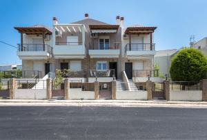 a large house with a fence in front of it at #Luxlikehome - Maisonette on the beach in Nikiti