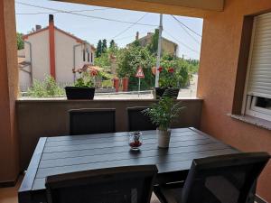 a table on a balcony with a view of a street at Apartmani Manda in Omišalj