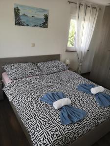 a bedroom with a bed with two towels on it at Apartmani Manda in Omišalj