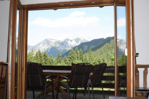 a table and chairs on a balcony with a view of mountains at Blockhütte Radmer in Radmer an der Hasel