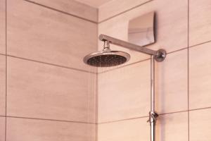 a shower with a shower head in a bathroom at bestprice Hotel Eschweiler in Eschweiler