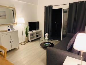 uma sala de estar com um sofá e uma televisão em Thalassa Sea View Suite em Limassol