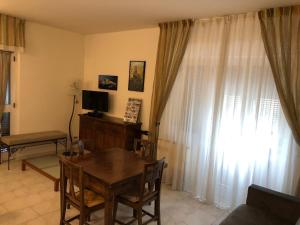 a living room with a table and a television and curtains at Casa Vacanza La Luna in Sarzana