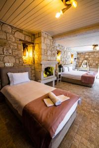 a bedroom with two beds and a stone wall at Çona Butik Otel in Alacati