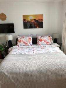 sypialnia z dużym łóżkiem z czerwono-białą pościelą i poduszkami w obiekcie De vier Berken 1 w mieście De Koog