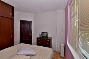 ein Schlafzimmer mit einem Bett und einem TV auf einer Kommode in der Unterkunft апартамент за гости Георгиеви in Weliko Tarnowo