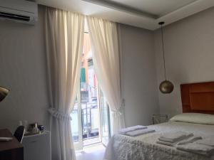 1 dormitorio con cama y ventana grande en “A piazzetta”, en Nápoles