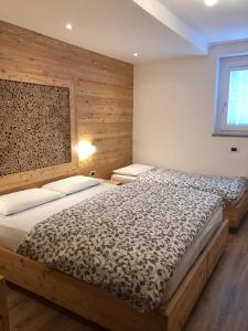 a bedroom with a bed and a wooden wall at Appartamenti Penasa Renato in Commezzadura