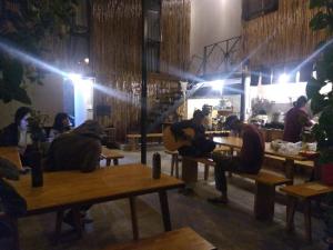 un grupo de personas sentadas en mesas en un restaurante en Komori House, en Da Lat