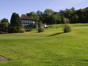 un campo de golf con un edificio y un green en Noddsdale Estate en Largs