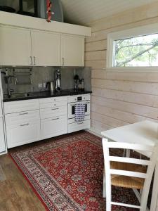 a kitchen with white cabinets and a red rug at 25 kvadrat 25 minuter från Åre in Järpen