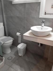 a bathroom with a sink and a toilet at Pergola Hotel in Agios Nikolaos