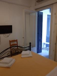 a room with a table with a chair and a television at Pergola Hotel in Agios Nikolaos
