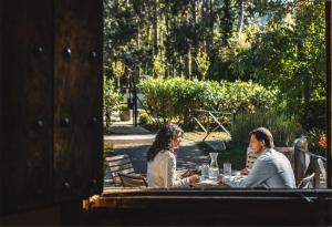 dos personas sentadas en una mesa en un jardín en Hotel Zubieta, en Lekeitio