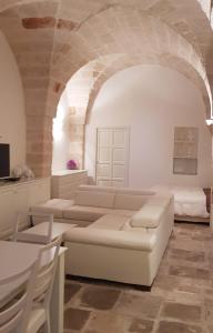 een witte woonkamer met een bank en een tafel bij La casa di Sara in Fasano