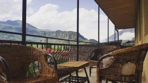 a balcony with chairs and tables and a view of mountains at Sunny Mountain House in Stepantsminda