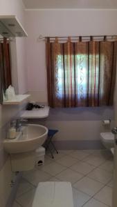 a bathroom with a sink and a toilet and a window at La Marina Resort in Pontida