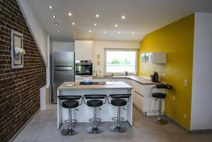 a kitchen with a counter and bar stools at LA BINAMERIE in Remicourt
