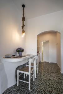 a kitchen with a white counter and chairs at Esmeralda Apartments in Apollonia