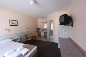 ein Hotelzimmer mit einem Bett und einem TV in der Unterkunft Lazy River Motor Inn in Swan Hill