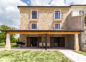 eine Außenansicht eines Steinhauses mit Terrasse in der Unterkunft Villa Luka in Brtonigla