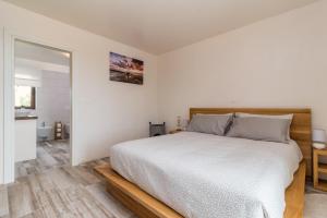 ein weißes Schlafzimmer mit einem Bett und einem Badezimmer in der Unterkunft Villa Luka in Brtonigla