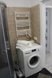 a washing machine in a bathroom with a shower at Sea Apartments in Kołobrzeg