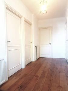 an empty room with two white doors and a wooden floor at In the old City Centre of Edam, unique apartment. in Edam