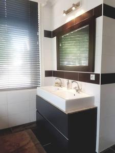 a bathroom with a sink and a mirror at In the old City Centre of Edam, unique apartment. in Edam