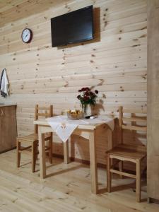 Green Villa Tskaltubo في تسكالتوبو: غرفة طعام مع طاولة وكراسي وتلفزيون