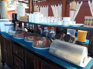 a buffet with dishes and a laptop on a table at Pousada Peixe Galo in Galinhos