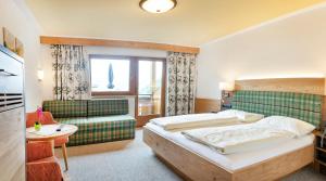 Łóżko lub łóżka w pokoju w obiekcie Landhotel Tirolerhof - Wildschönau - PREMIUM Card im Sommer