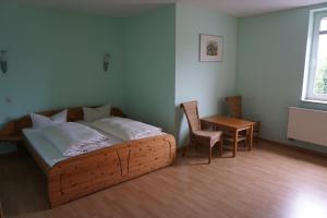 ein Schlafzimmer mit einem Bett, einem Tisch und einem Stuhl in der Unterkunft Hotel am Bahnhof in Waren (Müritz)