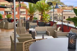 a patio with chairs and tables on a balcony at Hotel Villa Emilia in Barcelona