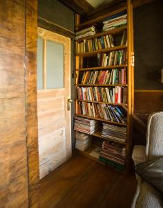 een kamer met een deur en een boekenplank gevuld met boeken bij Grenlanda in Ulanów