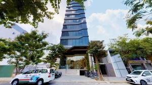 een hoog gebouw met auto's geparkeerd voor het bij Grand Ocean Luxury Boutique in Da Nang