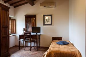a bedroom with a bed and a desk with a computer at B&B Le Caselle "Il Baraccotto" in Lucignano