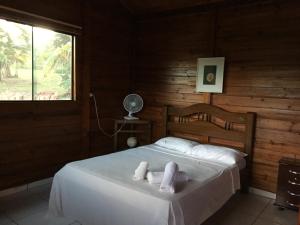 a bedroom with a bed with two towels on it at Rancho Ecologico Oasis de Luz in Abadiânia