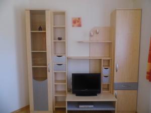 a room with a desk with a tv and shelves at Ferienwohnung Viehhauser in Hüttschlag