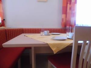 un tavolo di legno con piatti e bicchieri di Ferienwohnung Viehhauser a Hüttschlag Altre 2 foto
