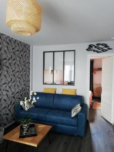 sala de estar con sofá azul y mesa en L'ENTRE 2 COTES, en Le Tréport
