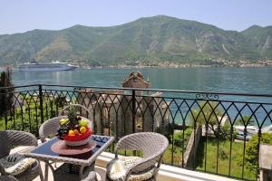 uma varanda com uma mesa com uma taça de fruta em Apartment FUNNY em Kotor